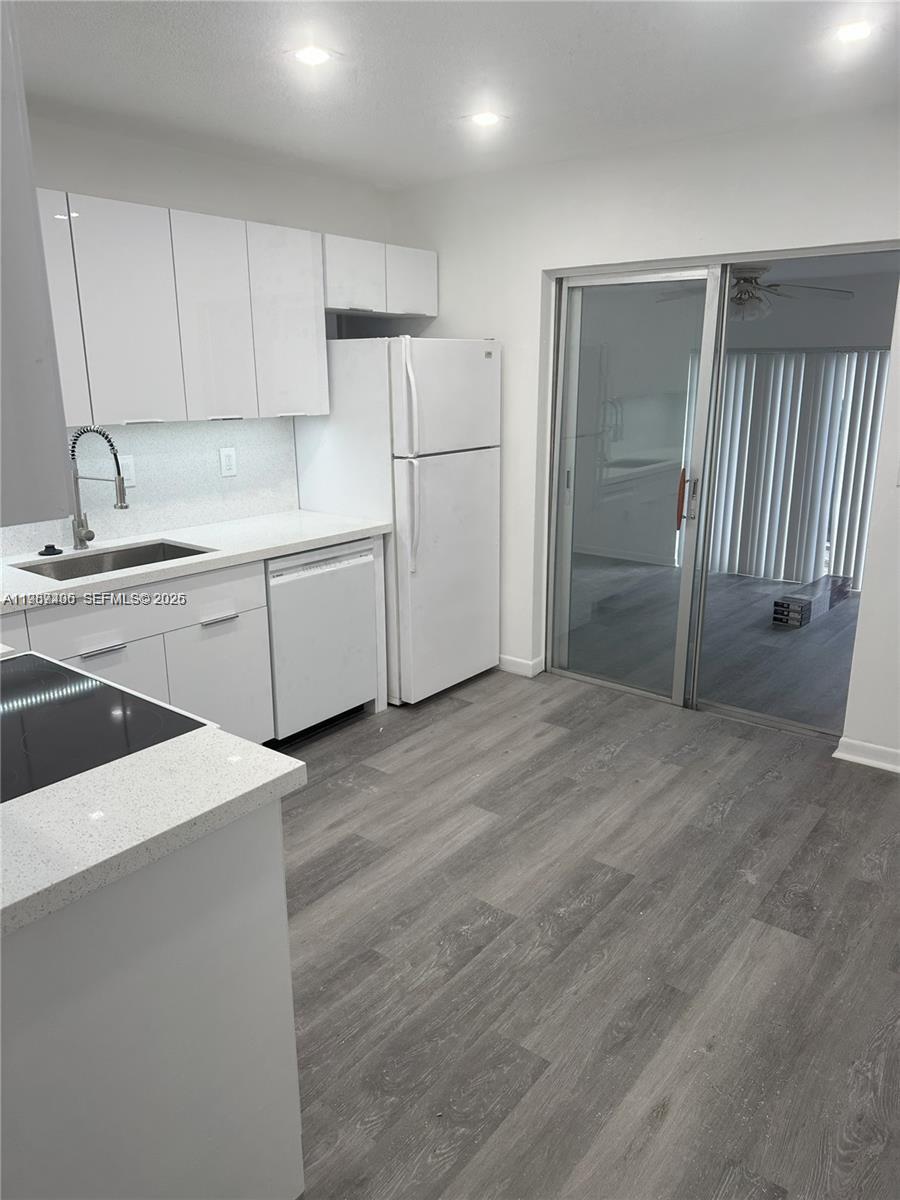 3268 Southwest 25th Street, Unit 3268 Miami, FL 33133 - Photo 8 of 17 a kitchen with a refrigerator sink and cabinets