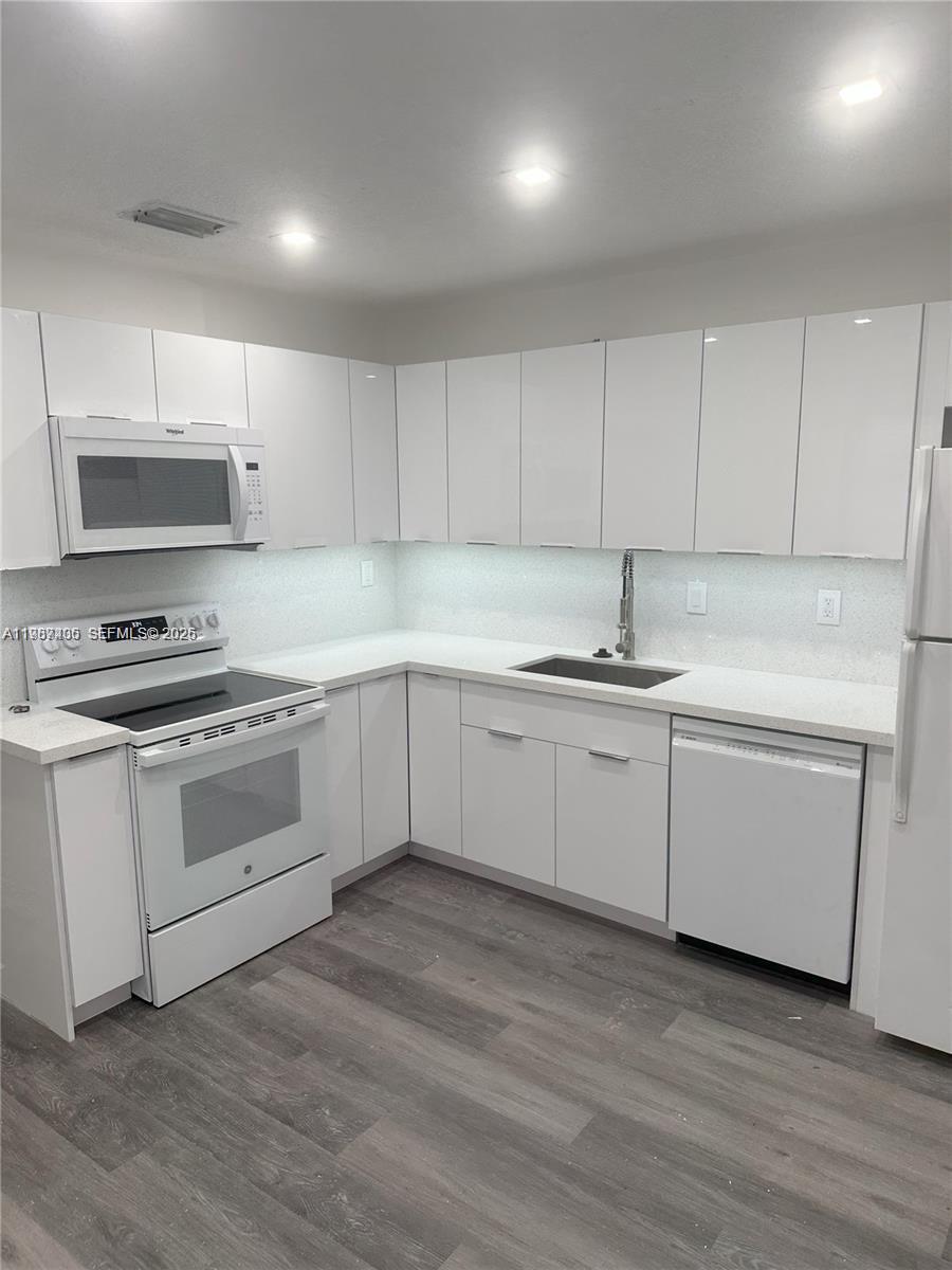 3268 Southwest 25th Street, Unit 3268 Miami, FL 33133 - Photo 9 of 17 a kitchen with granite countertop white cabinets and white appliances