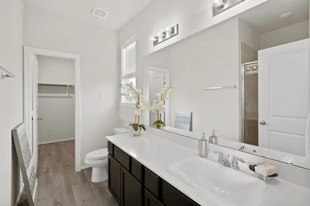 a bathroom with a sink double vanity and a toilet