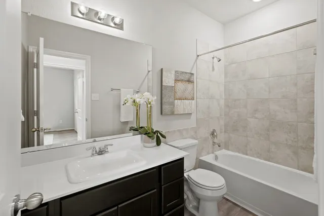 a bathroom with a double vanity sink toilet mirror and bathtub