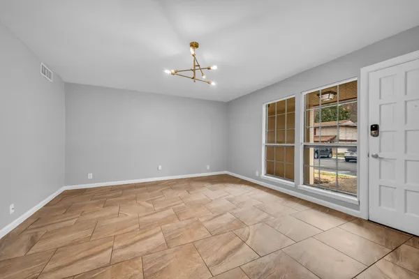 a dining room with furniture a chandelier and wooden floor