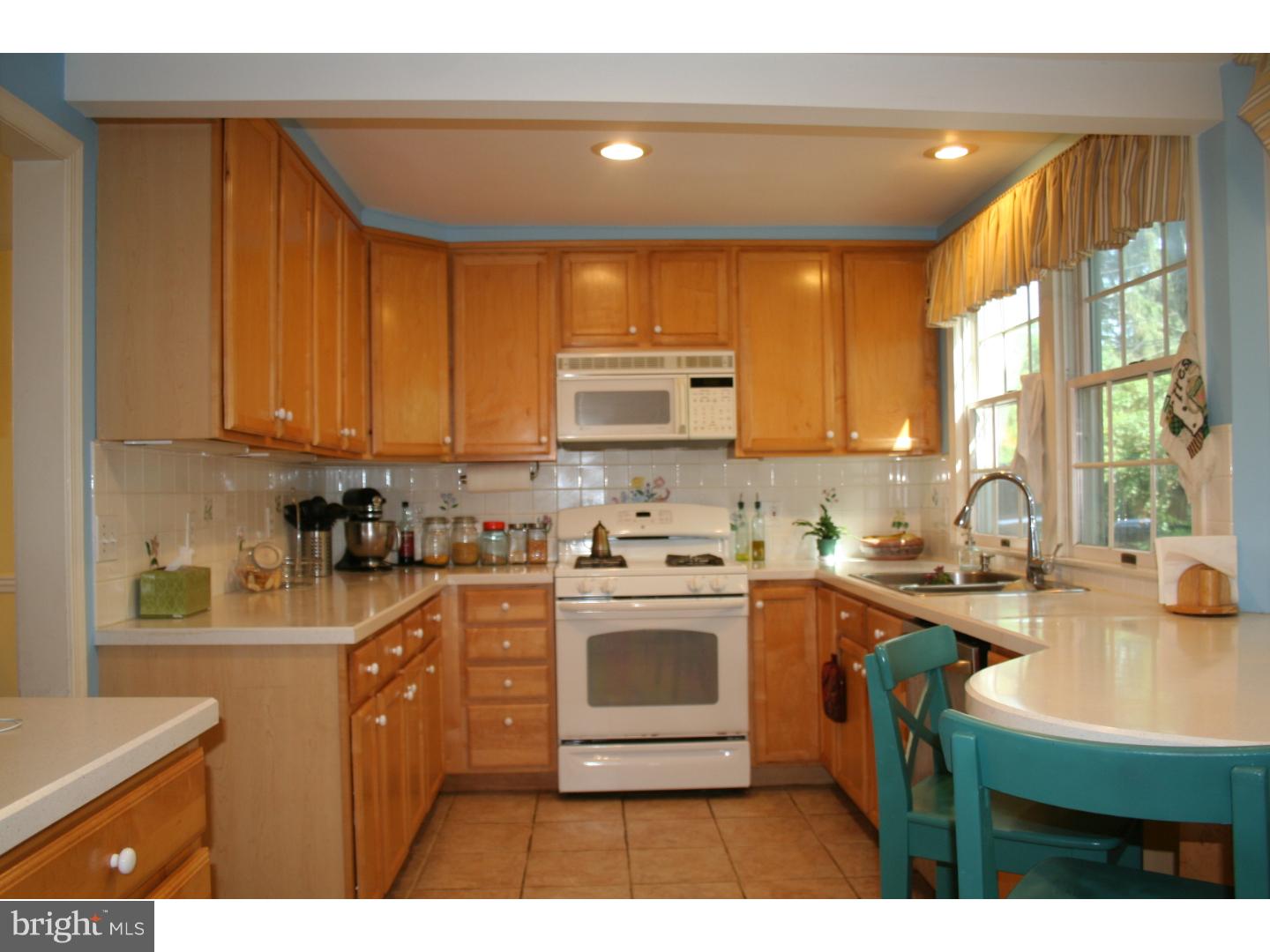 144 Henley Road Wynnewood, PA 19096 - Photo 7 of 21 a kitchen with a sink a stove a microwave cabinets and a counter top space