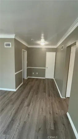 an empty room with wooden floor and closet