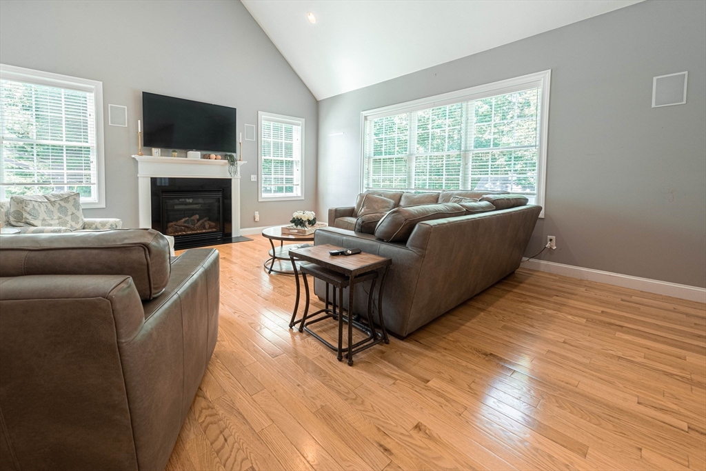 22 Jacob Road Windham, NH 03087 - Photo 11 of 42 a living room with furniture a flat screen tv and a fireplace
