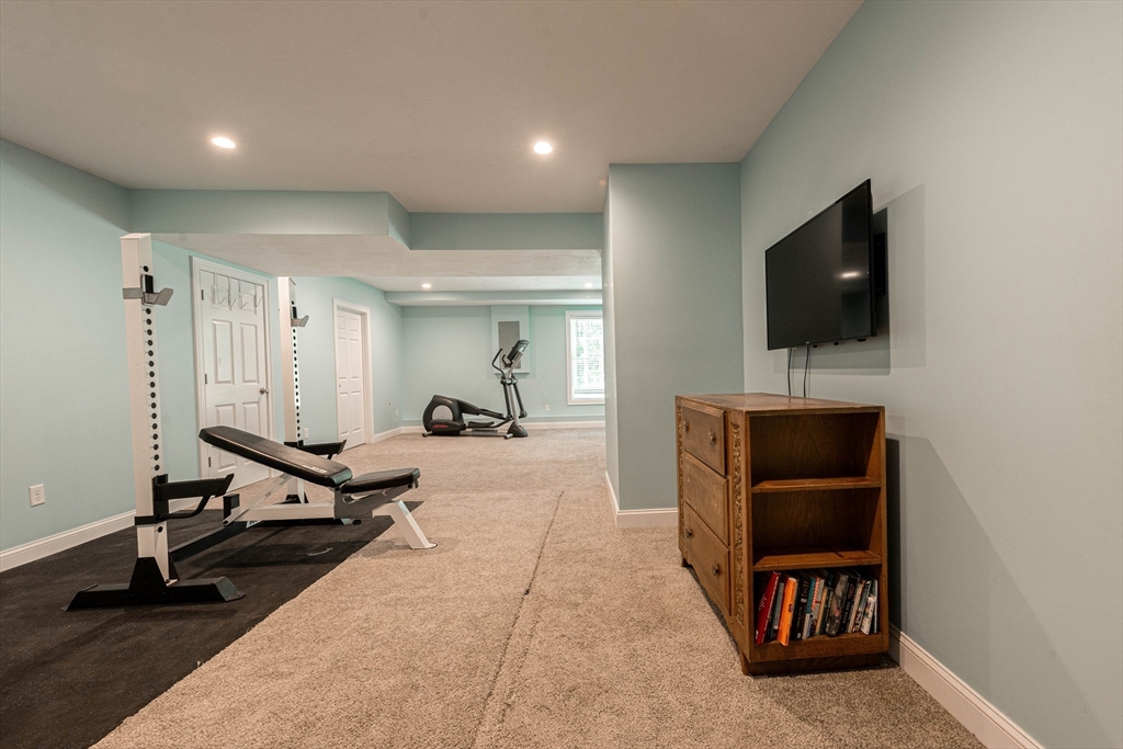 22 Jacob Road Windham, NH 03087 - Photo 33 of 42 a living room with furniture and a flat screen tv