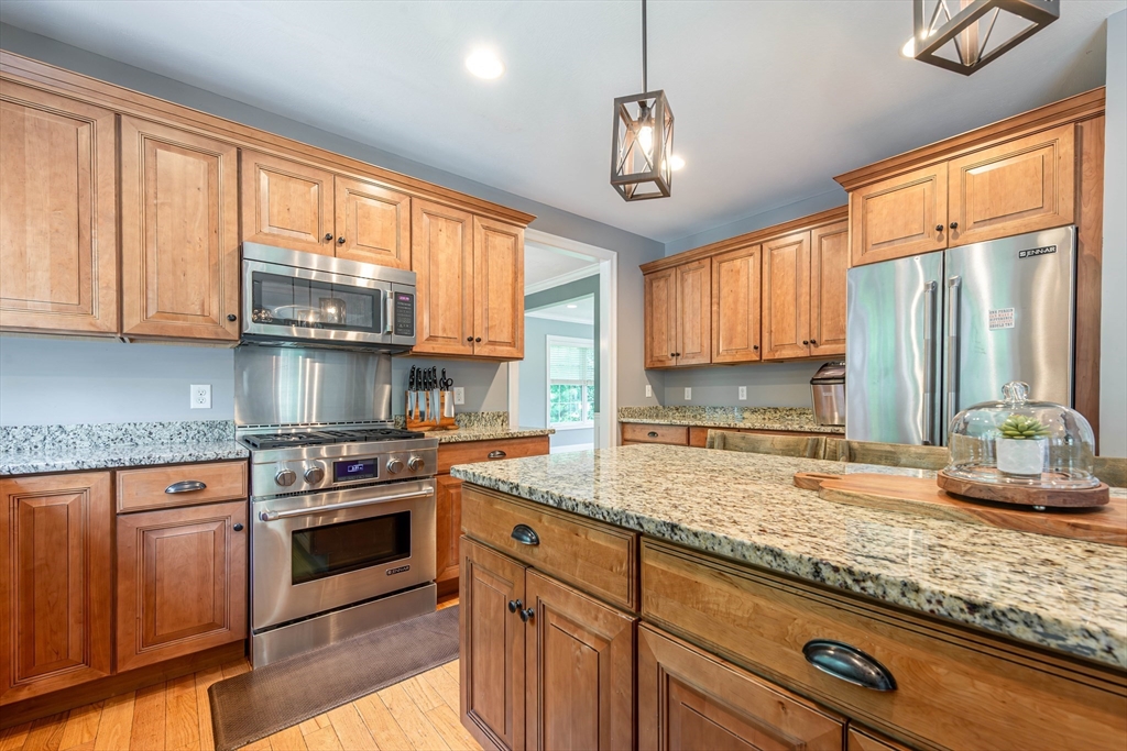 22 Jacob Road Windham, NH 03087 - Photo 7 of 42 a kitchen with stainless steel appliances granite countertop a sink a stove and cabinets