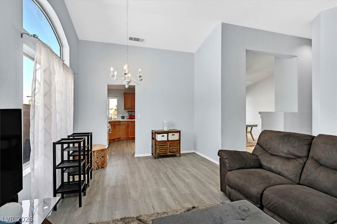 8830 Haviland Road Las Vegas, NV 89123 - Photo 6 of 43 High vaulted ceilings and wood-style flooring elevate this comfortable living space.