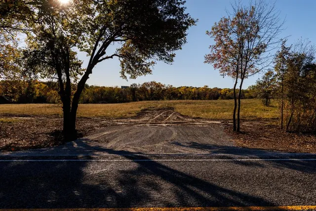 a view of a yard with wooden fence