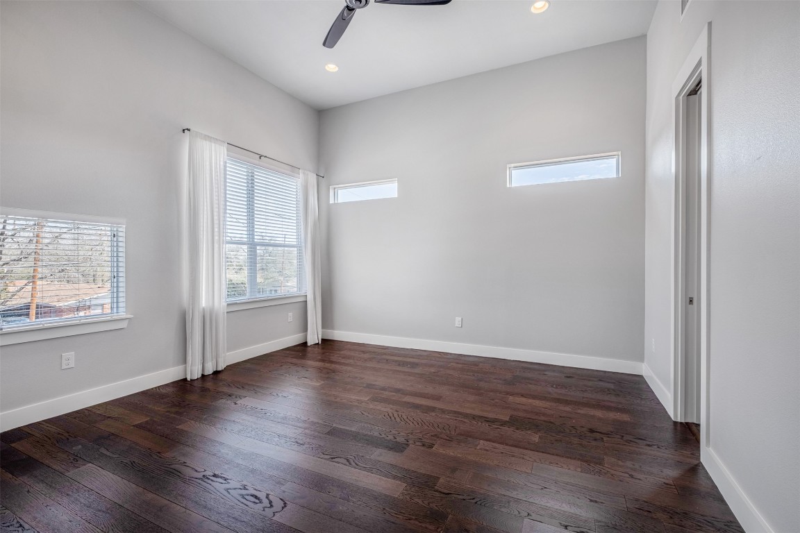 4707 Leslie Avenue, Unit A Austin, TX 78721 - Photo 18 of 24 Unfurnished bedroom featuring multiple windows, dark wood-style floors, ceiling fan, and recessed lighting
