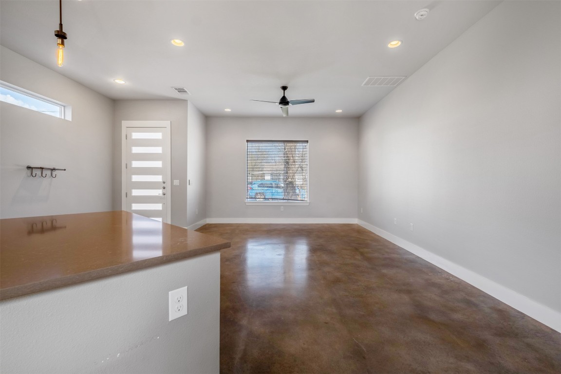 4707 Leslie Avenue, Unit A Austin, TX 78721 - Photo 7 of 24 Unfurnished living room with concrete flooring, a ceiling fan, and recessed lighting