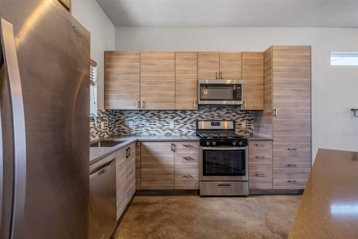 4707 Leslie Avenue, Unit A Austin, TX 78721 - Photo 8 of 24 Kitchen with stainless steel appliances, concrete flooring, and tasteful backsplash
