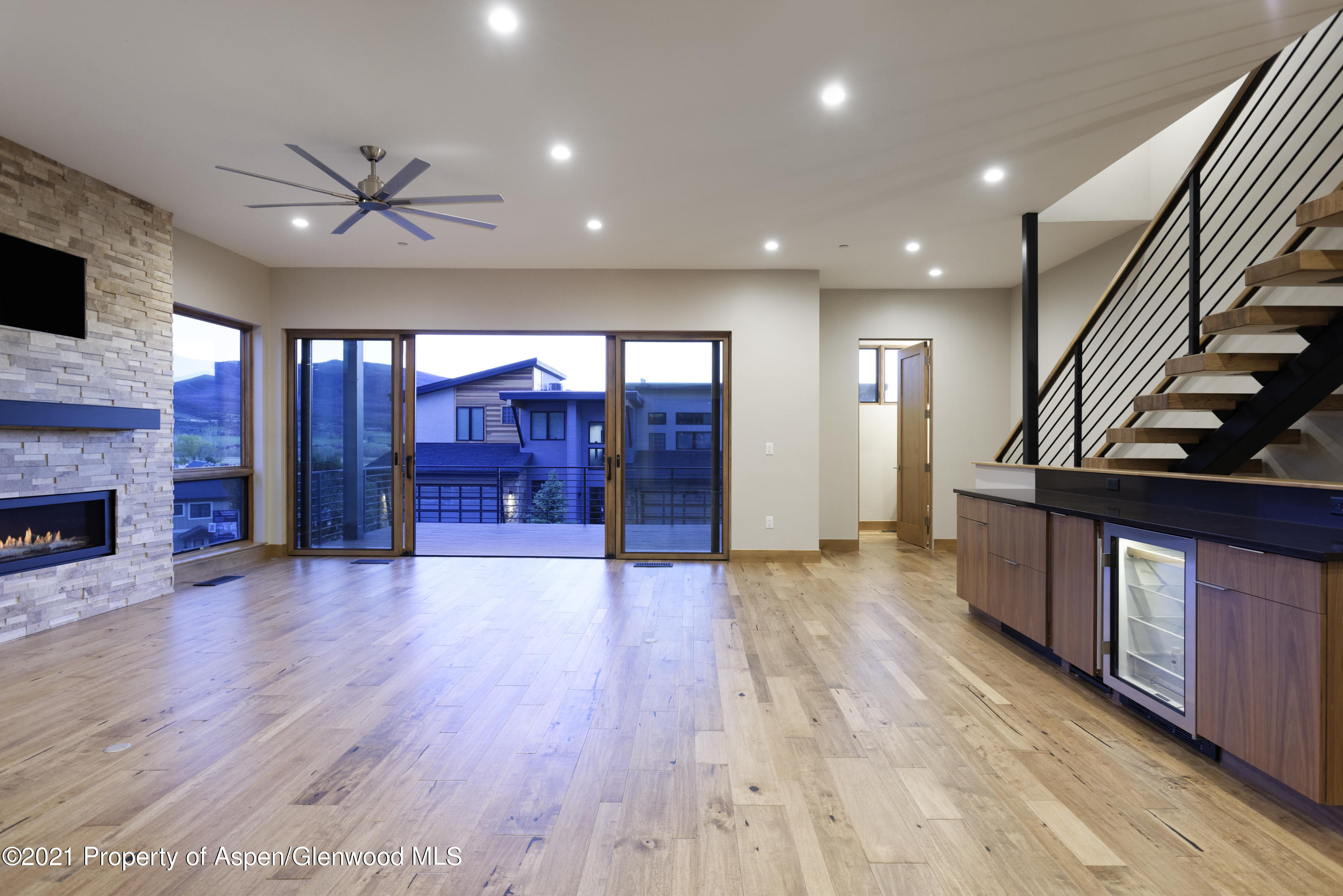 350 Overlook Ridge Basalt, CO 81621 - Photo 6 of 53 a view of an empty room with wooden floor a ceiling fan and windows