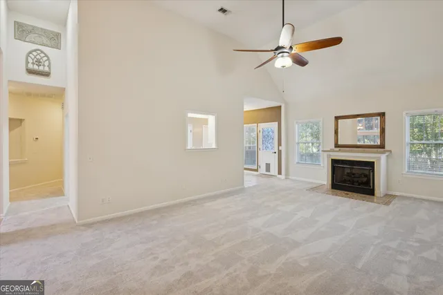 a view of an empty room with a fireplace and a window