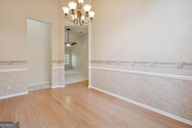 a view of a livingroom with wooden floor and a kitchen space