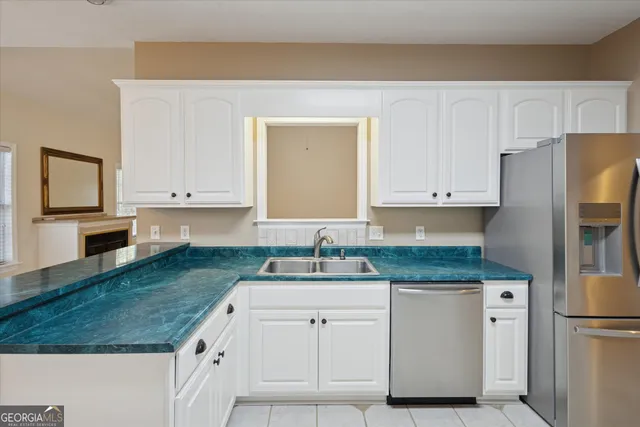 a kitchen with granite countertop white cabinets and white appliances