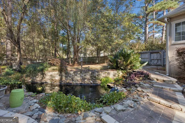 a view of a garden with potted plants and large trees