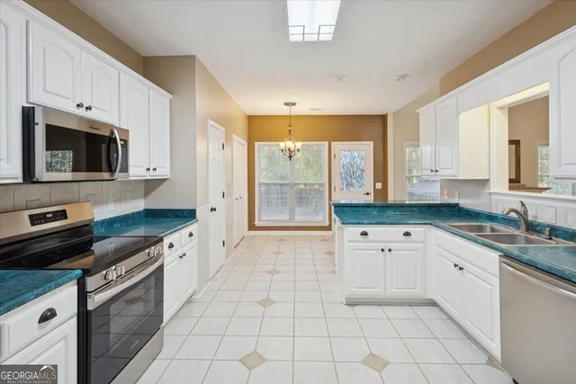 a kitchen with stainless steel appliances granite countertop a stove a sink and a microwave