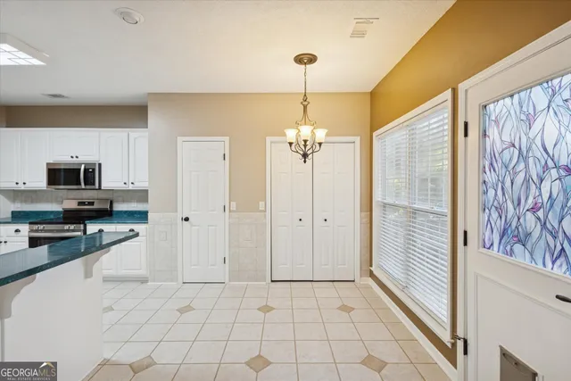 a large kitchen with a refrigerator a stove and a window