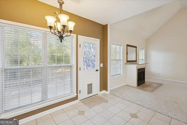 an empty room with chandelier fan and windows