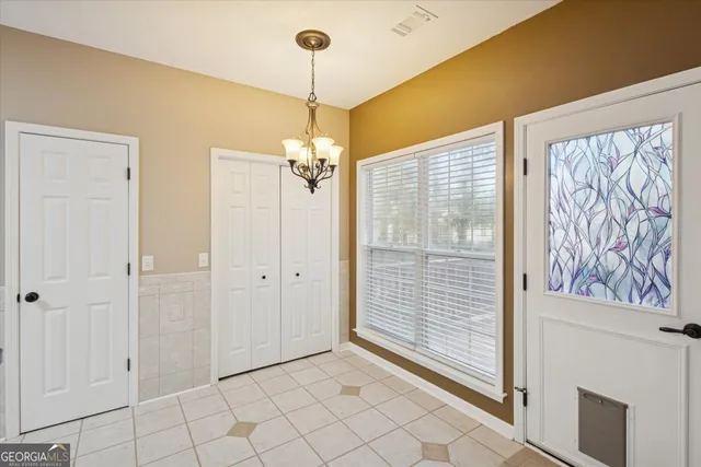 a view of a livingroom with a chandelier fan and windows