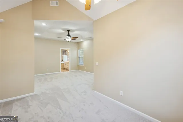 an empty room with an entryway and fan