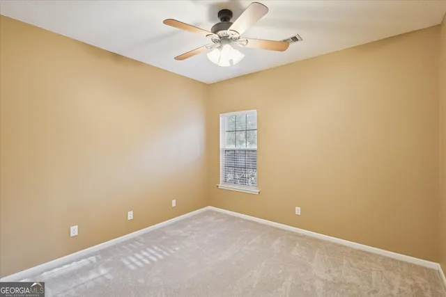 a view of a big room with windows and chandelier fan