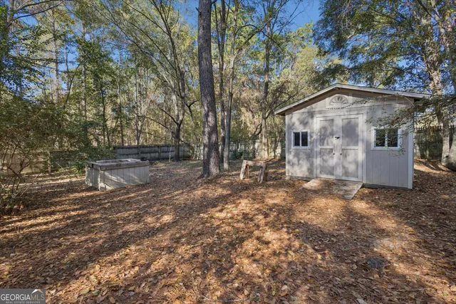a view of a forest with trees in the background