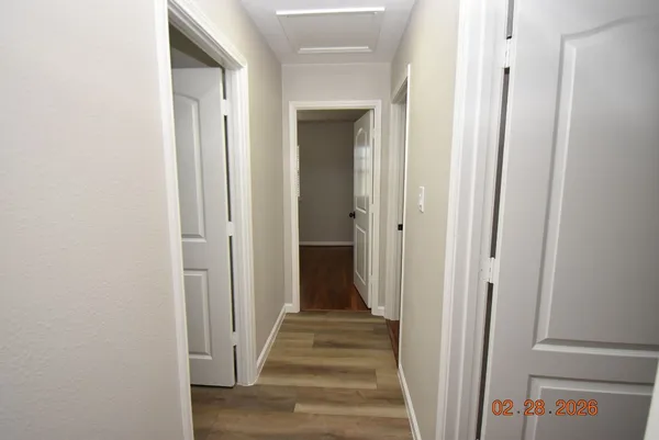a view of a hallway with wooden floor and entryway