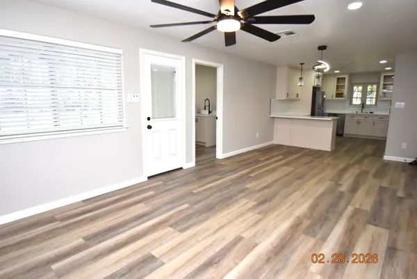 a view of a kitchen with wooden floor and a window