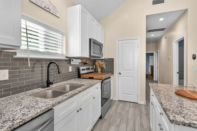 a kitchen with stainless steel appliances granite countertop a sink stove and refrigerator