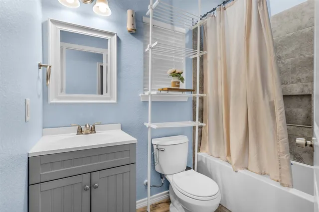 a bathroom with a sink a toilet and shower curtain