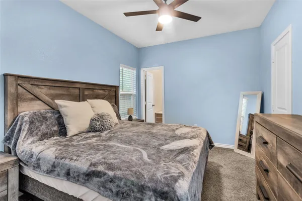 a bed sitting in a bedroom next to a window and a chandelier