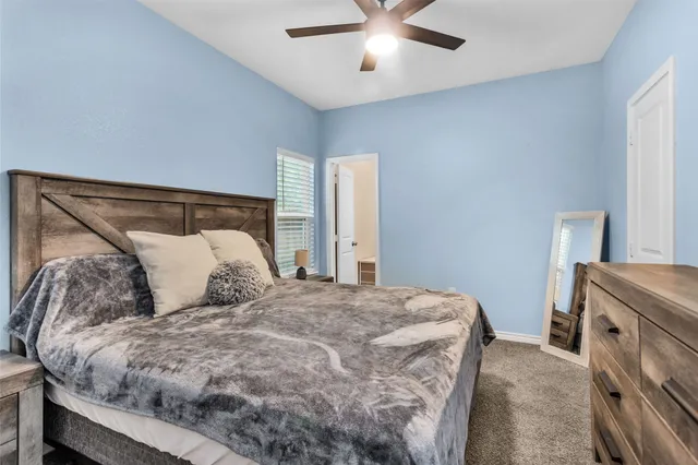 a bed sitting in a bedroom next to a window and a chandelier