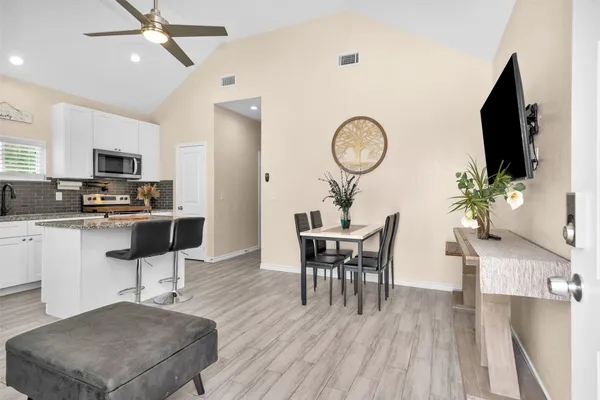 a living room with furniture a flat screen tv and kitchen view