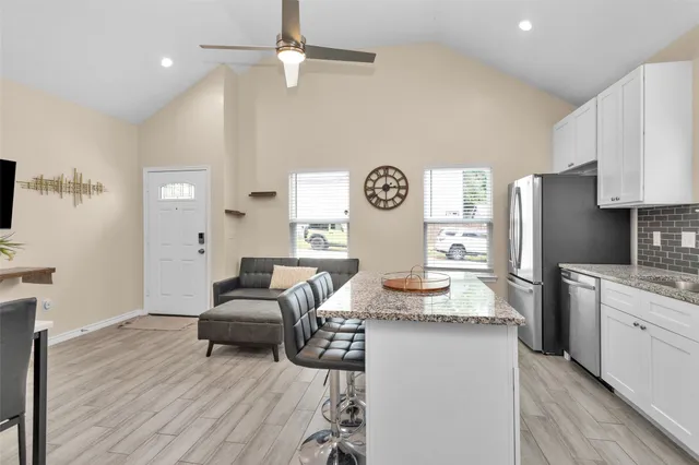 a living room with granite countertop furniture and a refrigerator