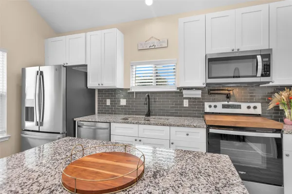 a kitchen with stainless steel appliances granite countertop a sink stove and refrigerator