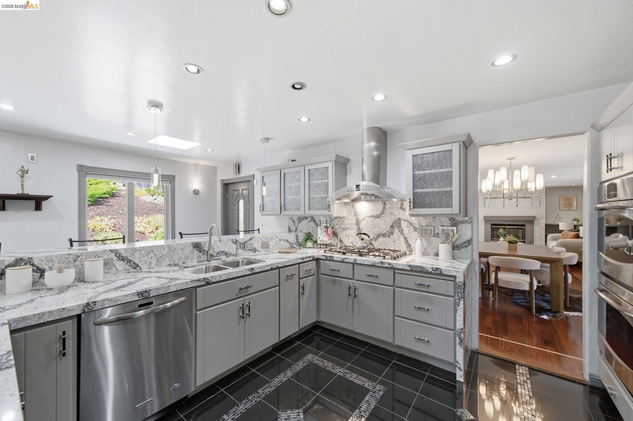 11133 Golf Links Road Oakland, CA 94605 - Photo 14 of 57 Contemporary kitchen with light grey cabinetry, granite countertops, and a full-height granite backsplash