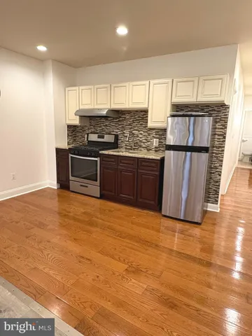 a kitchen with granite countertop a refrigerator and wooden cabinets