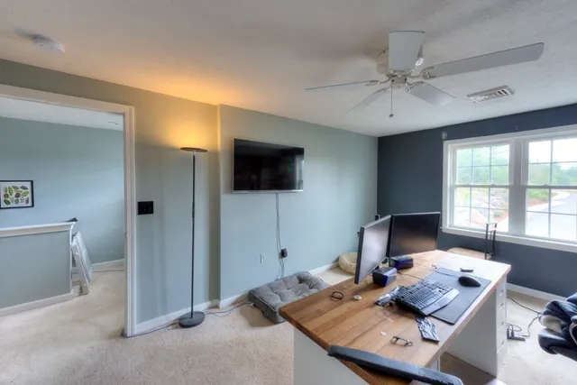a view of a workspace with furniture and a flat screen tv