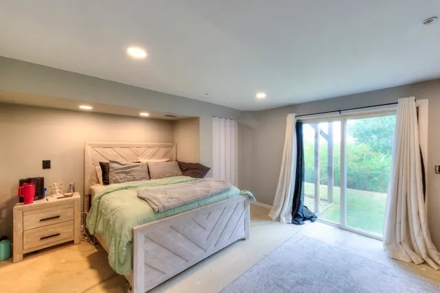 a bedroom with a bed and a large window