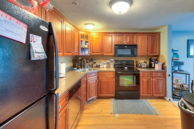 a kitchen with stainless steel appliances granite countertop a stove a sink and a refrigerator