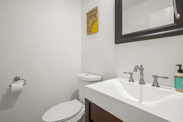 a bathroom with a sink a toilet and mirror