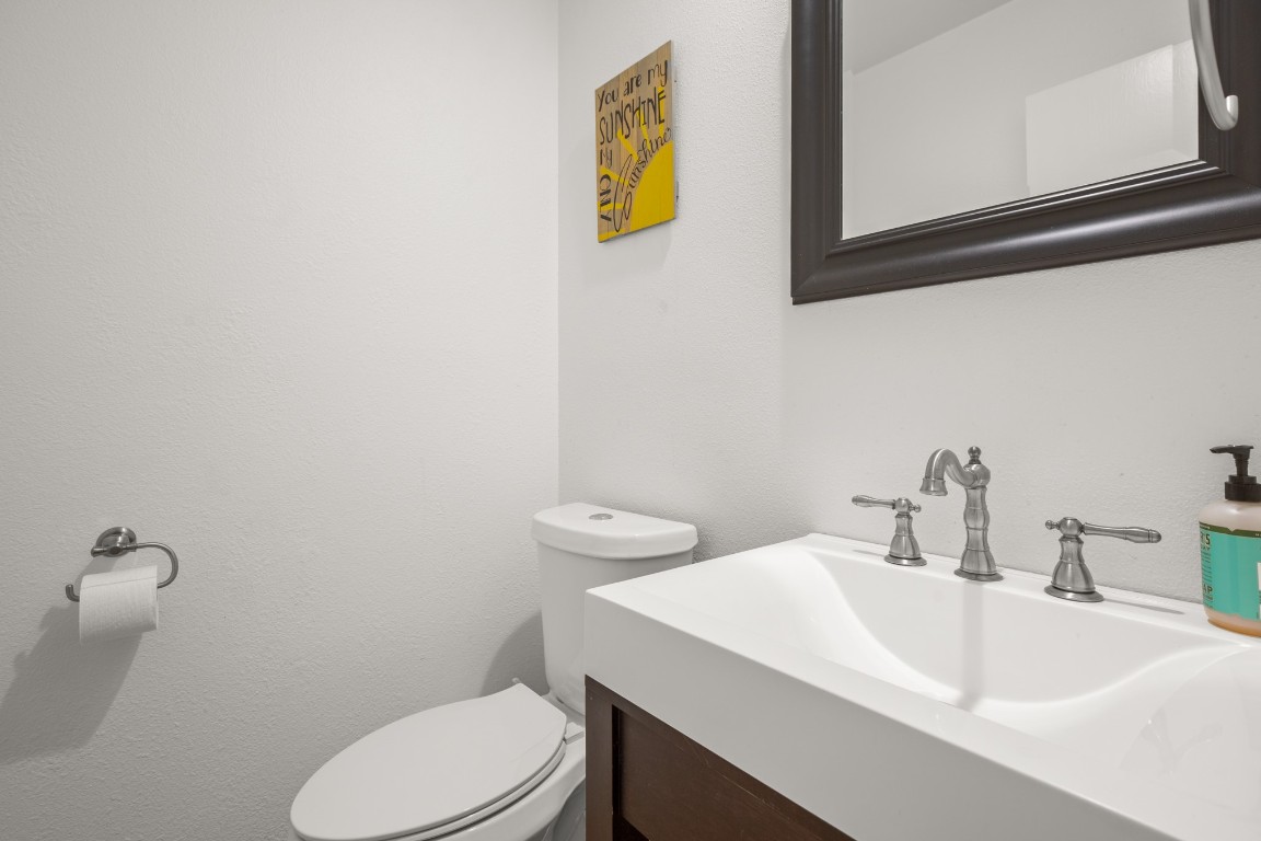 512 Eberhart Lane, Unit 1403 Austin, TX 78745 - Photo 3 of 15 a bathroom with a sink a toilet and mirror
