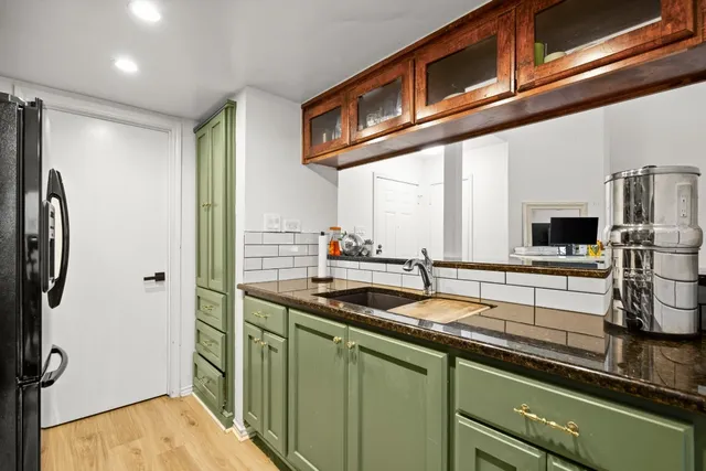 a kitchen with stainless steel appliances granite countertop a sink and a refrigerator