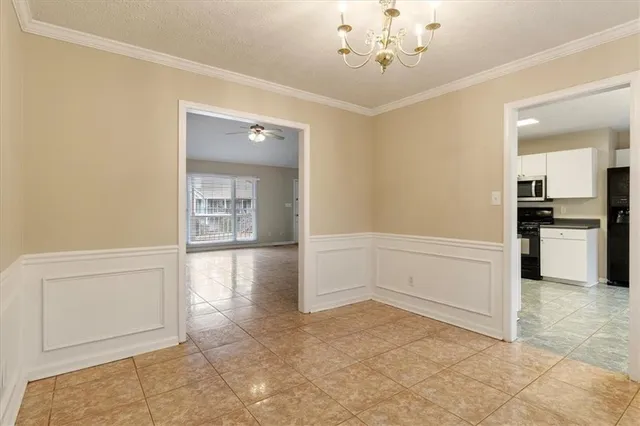 a kitchen with stainless steel appliances granite countertop a stove top oven a sink a refrigerator and white cabinets with wooden floor