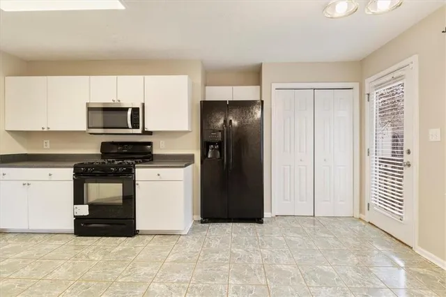 a kitchen with granite countertop a refrigerator stove top oven and sink