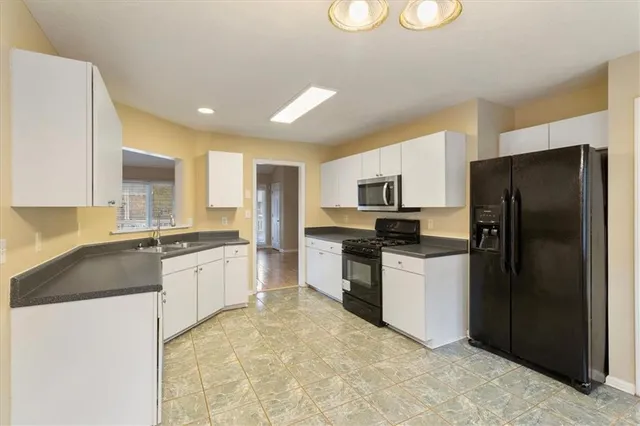 a kitchen with granite countertop a sink and cabinets