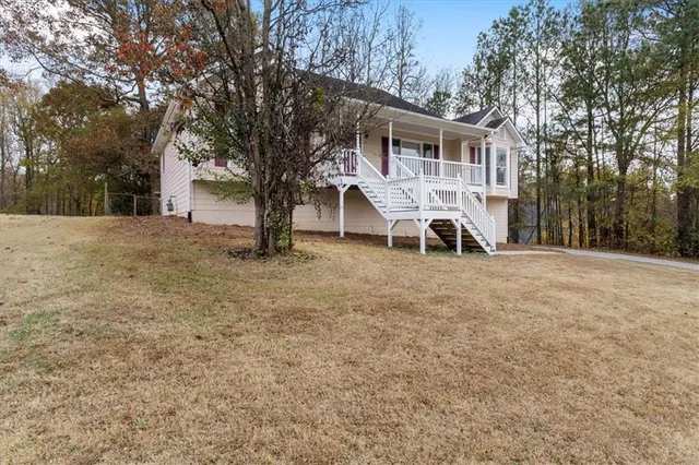 a view of a house with a yard and large trees