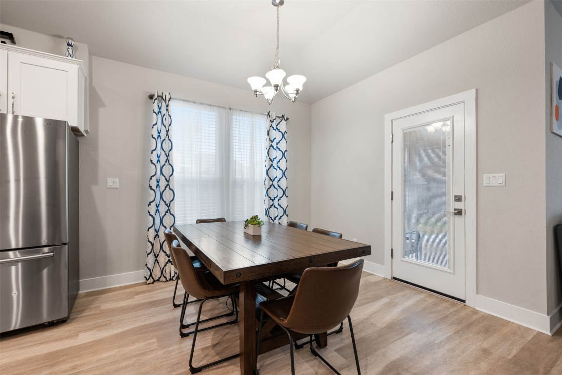 2212 Prairie Oaks Drive Georgetown, TX 78628 - Photo 17 of 39 a view of a dining room with furniture wooden floor and chandelier