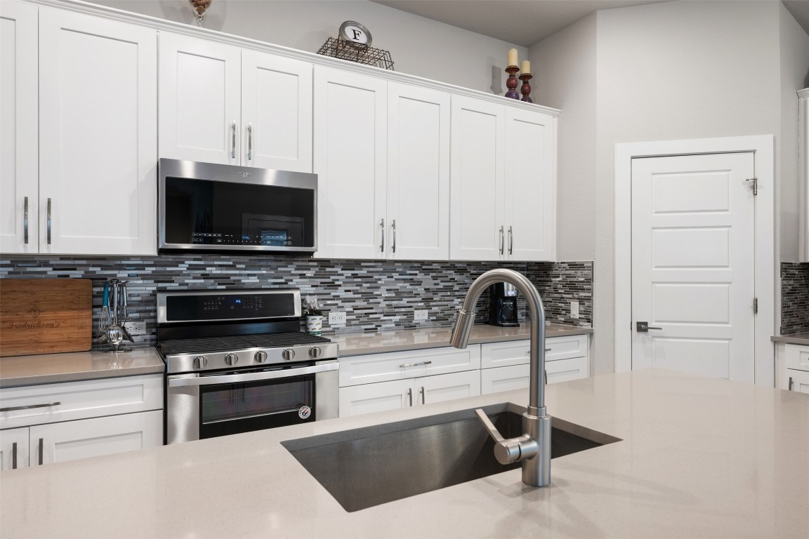2212 Prairie Oaks Drive Georgetown, TX 78628 - Photo 19 of 39 a kitchen with stainless steel appliances a stove and a microwave